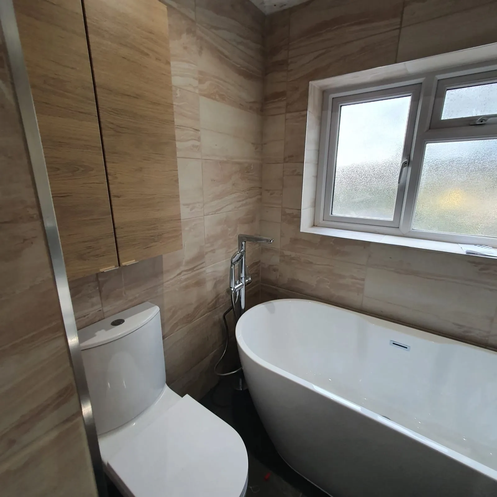Finished bathroom with freestanding bath and wood-effect wall tiles, Halifax